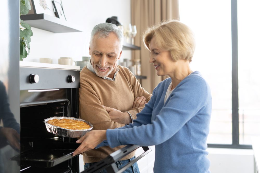 Ein Paar mittleren Alters backt gemeinsam Apfelkuchen.